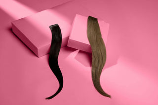 Black and brown hair extensions displayed on pink boxes and pink background, showcasing their texture and color.