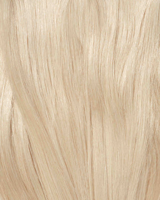 A detailed view of long, wavy platinum blonde hair extensions, highlighting their softness and elegant flow.