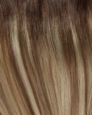 A close-up of hair featuring melrose balayage with blonde and brown tones blended together.