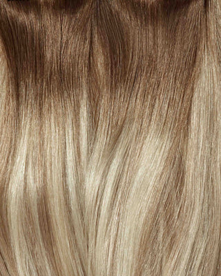 A close-up of Cream Beige Balayage hair extensions displayed on a white background, showcasing their texture and color blend.