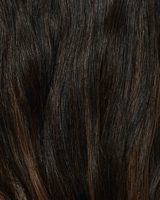 A close-up of a woman's hair showcasing dark brown highlights in a beautiful Hawaii balayage style.