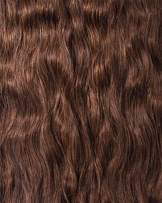 A close-up of wavy brown hair extensions, showcasing their texture and shine.