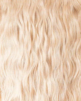 A close-up of wavy blonde hair extensions, showcasing their texture and shine in a vibrant, natural light.