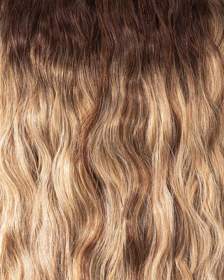 A close-up of long, wavy hair extensions showcasing their texture and shine.