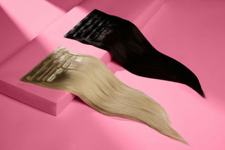 Two sets of clip-in hair extensions, one black and one blonde, displayed on a pink background with soft lighting.