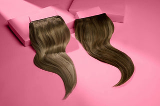 A pair of long wavy hair extensions set on a pink background, highlighting their flowing style and vibrant appearance.